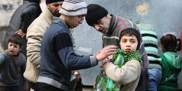 Zivilisten in Ost-Aleppo füllen Flaschen mit Wasser