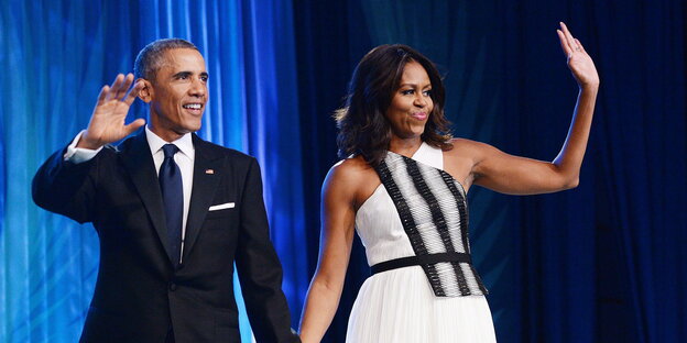 Michelle und Barack Obama winken von einer Bühne
