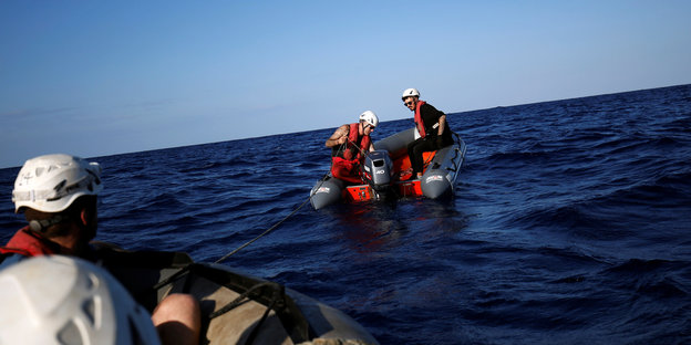 Menschen in Sicherheitsausrüstung auf Schlauchbooten