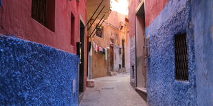 Eine Gasse. Die Wände in rot und blau gestrichen.