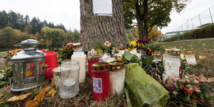 Kerzen und Blumen stehen vor einem Baum