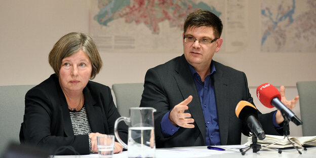 Katrin Lompscher und Andrej Hom sitzen an einem Tisch bei einer Pressekonferenz
