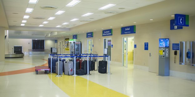 Viele Koffer innerhalb eines engen abgesperrten Terrains in einem Flughafengebäude