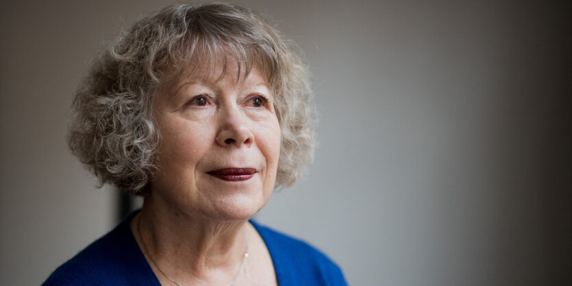 Das Protrait einer Frau mit grauen Locken und einem blauen Blazer