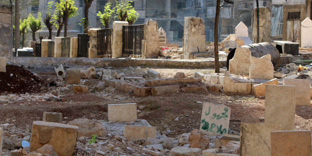 Gräber in Aleppo. Im Hintergrund Trümmer