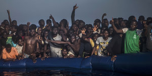 Viele Menschen stehen auf einem Schlachboot vor der libyschen Küste