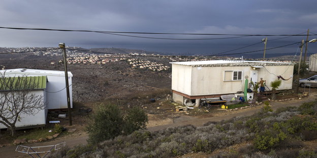 Mehrere weiße Wohncontainer der illegalen Siedlung Amona im Westjordanland stehen auf einem Hügel, im Hintergrund ist die Siedlung Ofra zu sehen