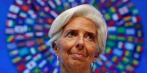 eine Frau vor einem Kranz, der aus den Flaggen der IWF-Staaten besteht