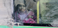 Ein Mädchen guckt aus einem Bus, mit dem sie aus Ost-Aleppo fliehen kann