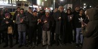 Flüchtlinge stehen mit Kerzen am Breitscheidplatz