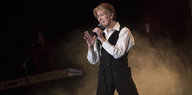 Ein Mann, der beinahe aussieht wie David Bowie, in Anzug auf einer Bühne