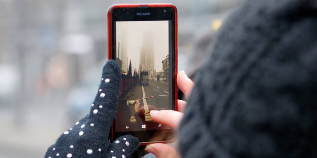 Jemand fotografiert den Tatort am Breitscheidplatz mit seinem Smartphone