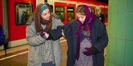 Zwei Frauen in der Münchner S-Bahn. Die eine ist schwanger und hält sich den Bauch. Die andere stützt sie.