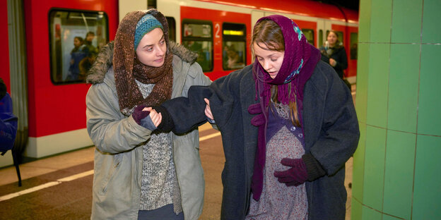 Zwei Frauen in der Münchner S-Bahn. Die eine ist schwanger und hält sich den Bauch. Die andere stützt sie.