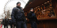 Polizisten patrouillieren über einen Weihnachtsmarkt in Berlin.