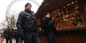 Polizisten patrouillieren über einen Weihnachtsmarkt in Berlin.