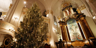 Ein Tannenbaum mit Lametta vor dem Altar in einer barocken Kirche