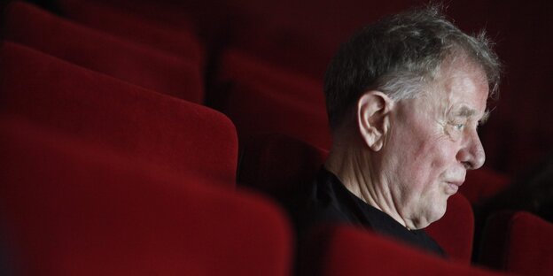 Claus Peymann sitzt in den roten Stuhlreihen des Wiener Akademietheaters