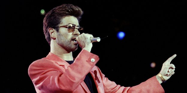 George Michael steht 1992 im roten Sakko auf der Bühne