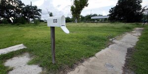 Ein Postkasten steht auf einer Rasenfläche