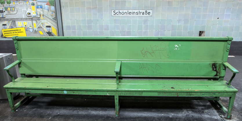 Eine grüne Bank in einem U-Bahnhof