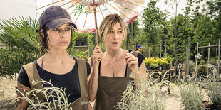 Micaela Ramazotti (l.) und Valeria Bruni Tedeschi unter einem Sonnenschirm in einer Gärtnerei