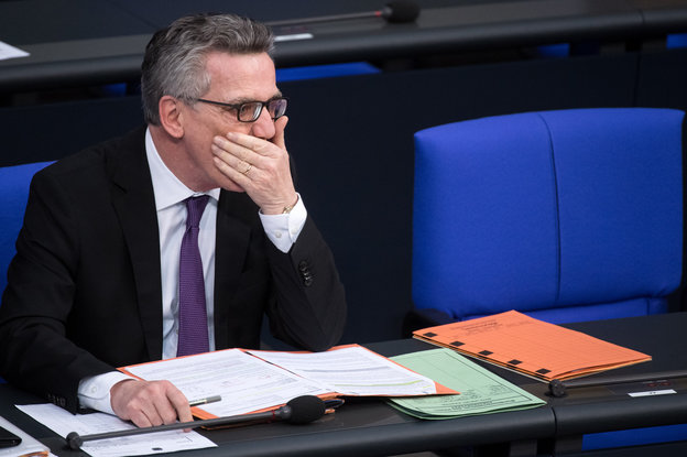 De Maizièrre im Bundestag auf seinem Platz im Bundestag. Hölt sich die hand vor den Mund.