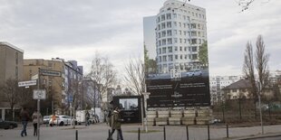 An einer Straßenecke steht ein Schild, auf dem luxuriös aussehendes Haus zu sehen ist