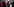 Menschen mit Masken von Trump und Clinton
