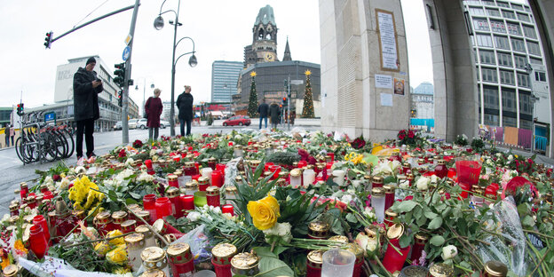 Blumen und Kerzen, im Hintergrund die Gedächtniskirche in Berlin