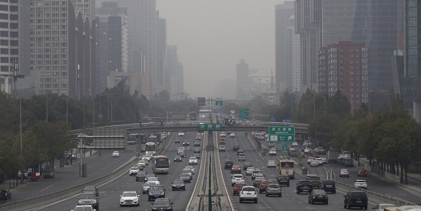 Mehrspurige Stadtstraße, im Hintergrund Smog