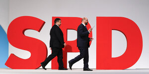 Vor einem großen roten SPD-Logo laufen Sigmar Gabriel und Martin Schulz entlang
