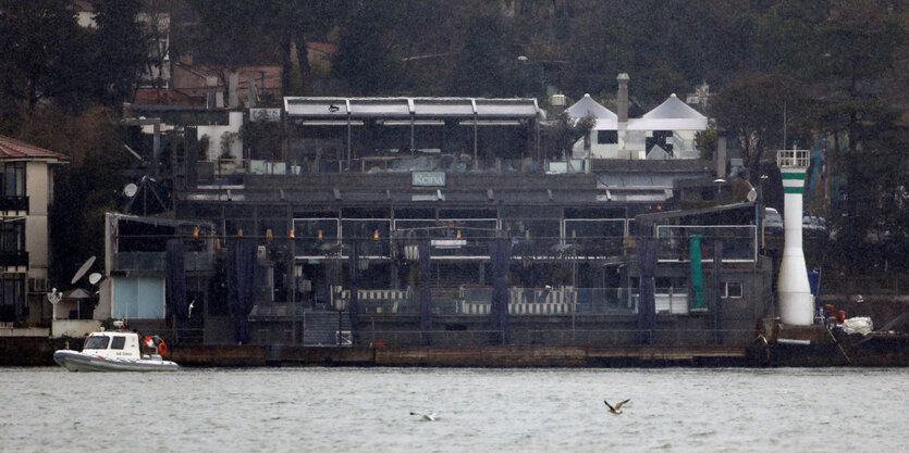 Ufer mit einem Haus, davor liegt ein Boot