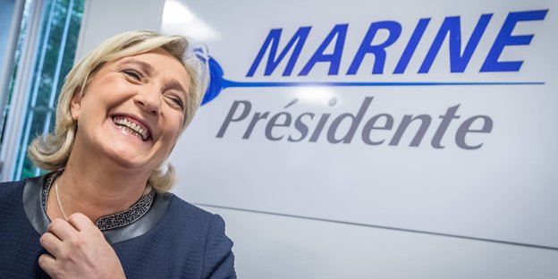 Marine Le Pen vor einem Wahlkampfplakat