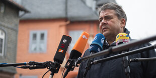 Sigmar Gabriel steht vor Mikronfonen und gibt ein Presse-Statement ab.