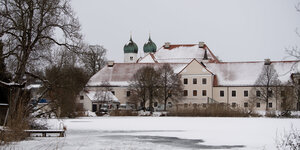 Ein Gebäude vor einem zugefrorenen See, überall liegt Schnee