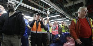 Mitarbeiter einer Fabrik applaudieren