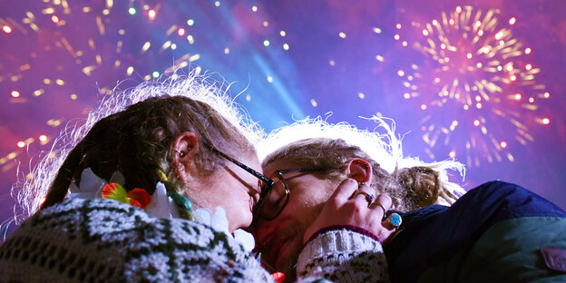 Zwei Menschen küssen sich unter Silvester-Feuerwerk