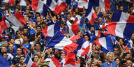 Eine Menschenmenge mit französischen Flaggen auf der Tribüne eines Fußballstadions