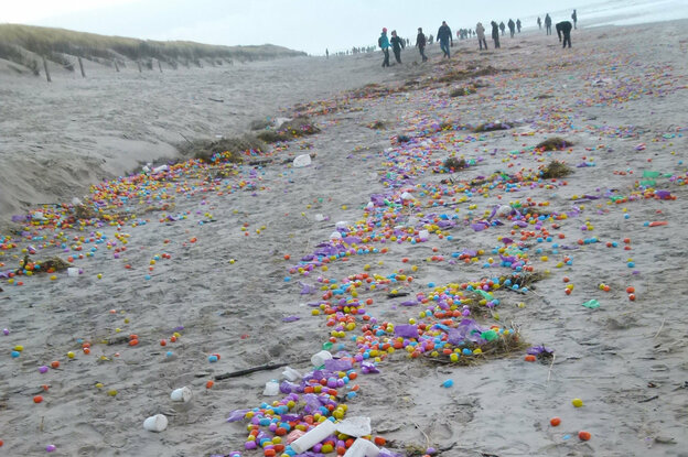 Der Strand von Langeoog: Eine Spur von bunten Eiern, Plastikabfall Tang zieht sich durch den Sand. Weit entfernt geht eine Gruppe von Menschen, ein Mann bückt sich, um Eier einzusammeln.