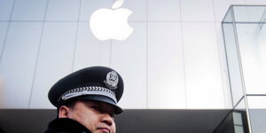 Ein chinesischer Polizist steht vor einem App-Store in Peking
