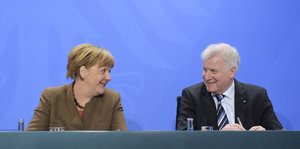 Angela Merkel und Horst Seehofer grinsen sich an