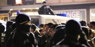 Polizeibeamte und männliche Besucher stehen sich in der Silvesternacht in Köln gegenüber