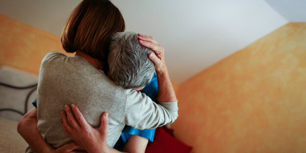 Eine Frau umarmt einen körperlich behinderten Mann