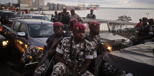Soldaten sitzen auf einem Laster mitten im Straßenverkehr