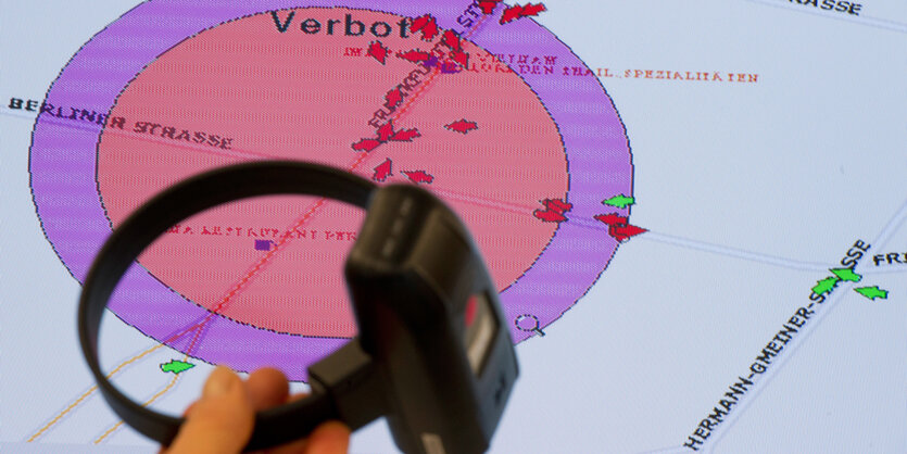 Eine elektronische Fußfessel vor einem Bildschirm, der die Verbotszone darstellt