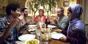 "Tatort"-Kommisar Brix und seine Vermieterin sitzen mit ihren Gästen aus einer Flüchtlingsunterkunft beim Abendessen zusammen