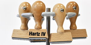 vier Stempel, auf einem steht „Hartz IV“