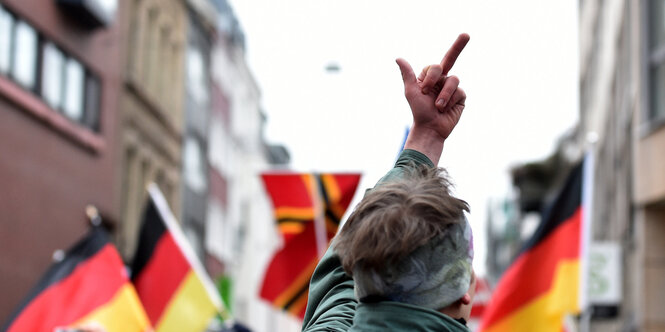 Ein Gegendemonstrant zeigt den Teilnehmern von Pro NRW den Stinkefinger