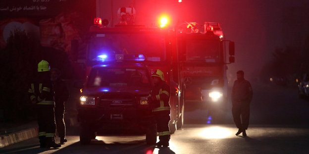 Feuerwehrautos stehen in der Dunkelheit auf einer Straße